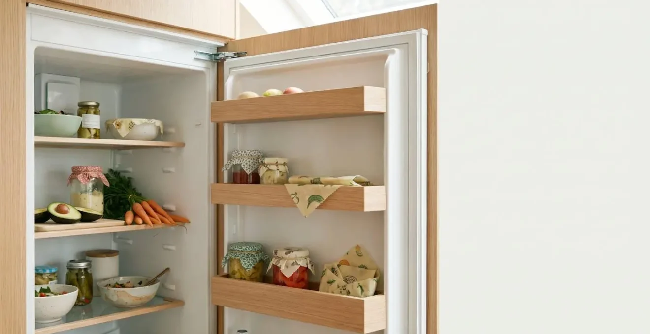 Intérieur d'un réfrigérateur en location de vacances avec restes de nourriture à gérer avant le départ